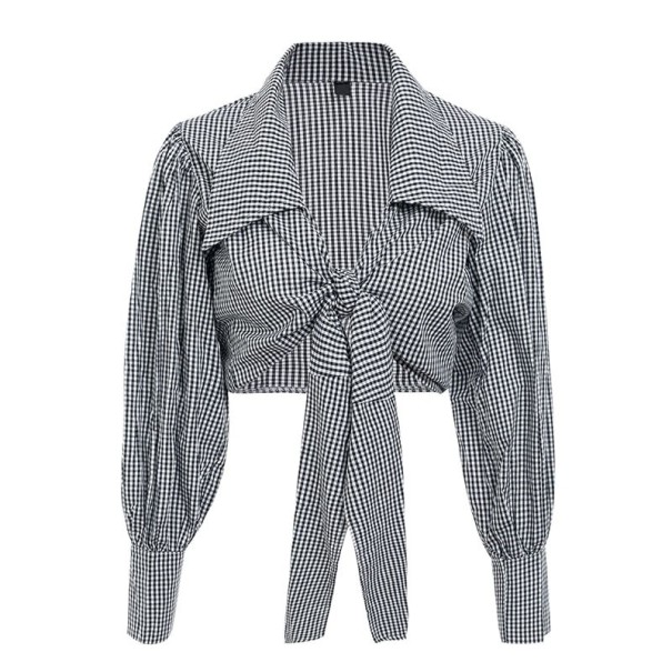 Dam svartvit blus med rutmönster Kort skärning med knytning i mitten av bysten Lätta ärmar med manschetter Bomull och polyester S