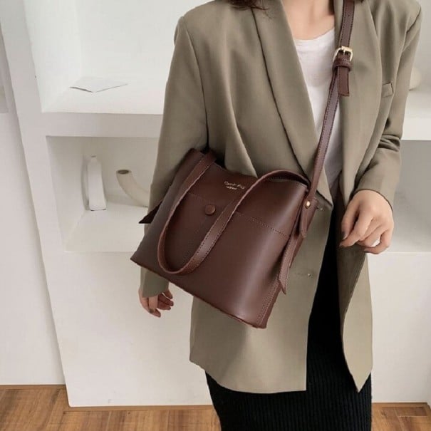 Dams crossbody-väska i PU-läder Två handtag och lång rem med spänne Bärs i handen eller över axeln Mått 25,5 x 22 x 11 cm mörkbrun