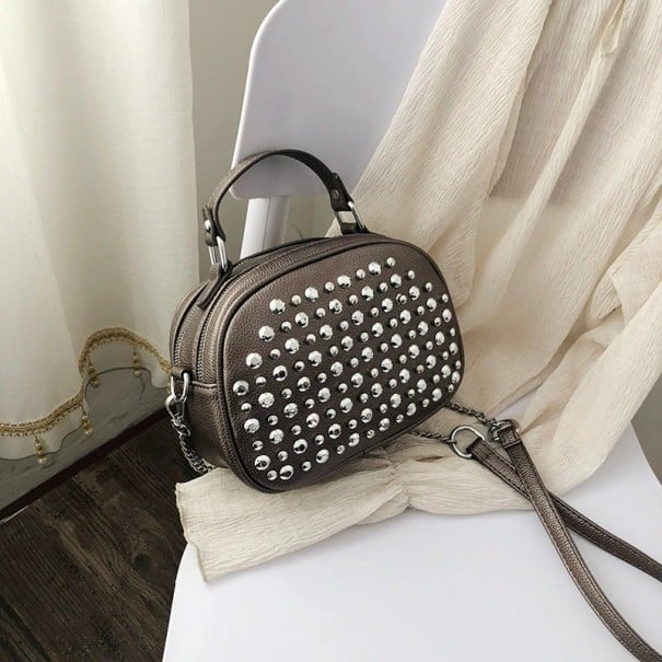 Dams oval crossbody väska med metallnitar av PU-läder Övre handtag Axelrem med kedja Dragkedjestängning Mått 20 x 16 x 10 cm mörkgrå
