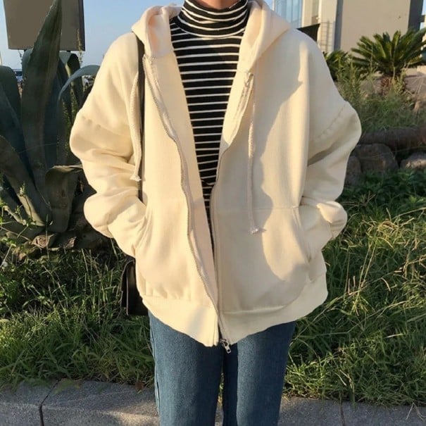 Damhoodie med dragkedja och snörning Löst oversize snitt Sänkta axlar Två framfickor Ribbad mudd Polyester och bomull krämfärgad