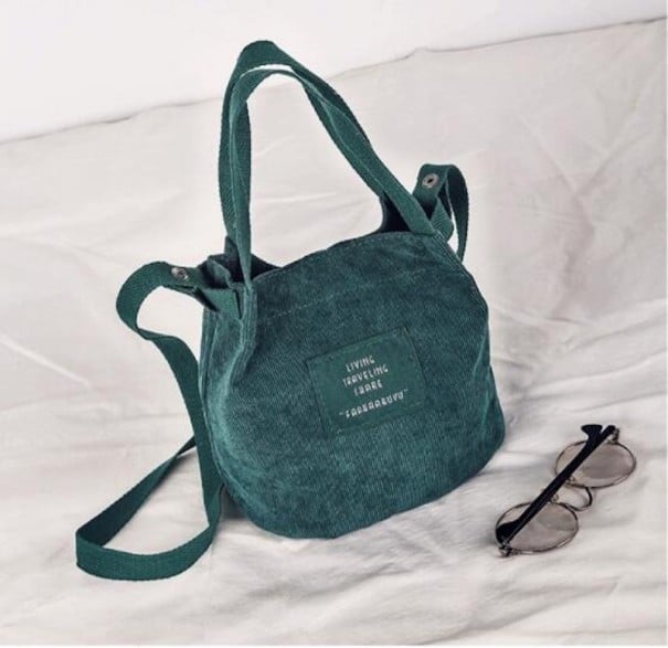 Liten damhandväska av polyester Ribbat yta Två korta handtag Lång axelrem Textilapplikation Mått 21 x 19 x 12 cm mörkgrön