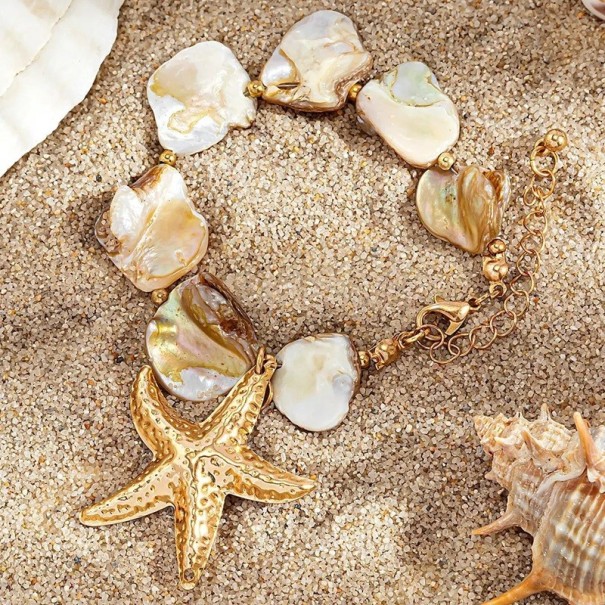 Bracciale con articoli in madreperla e ciondolo a forma di stella marina, decorazione in tonalità dorata, bracciale da donna di grande bianco