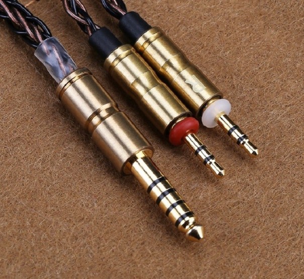 Cabo de áudio trançado de cobre com conector de 4,4 mm jack para dois conectores de 2,5 mm jack de cores diferentes. Carcaças de cor dourada 1