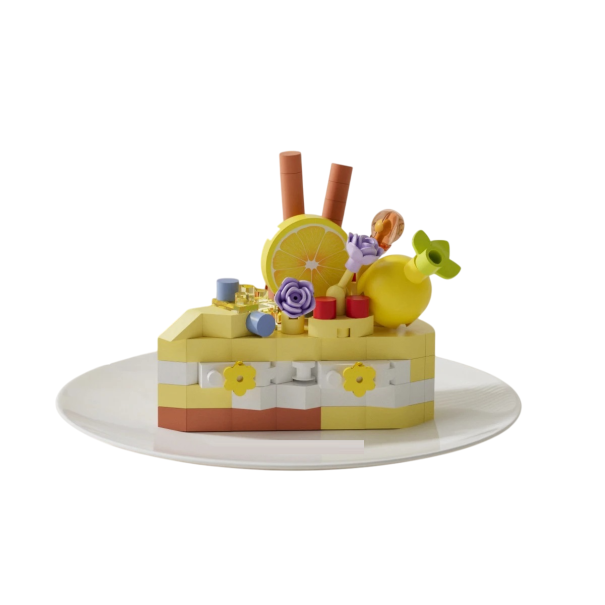 Costruzione 5,5 x 3,5 x 4,5 cm di un dessert a forma di torta in tonalità gialle e bianche con decorazioni di limone, fiori e dettagli a forma di frutta e stecche da assemblare 1