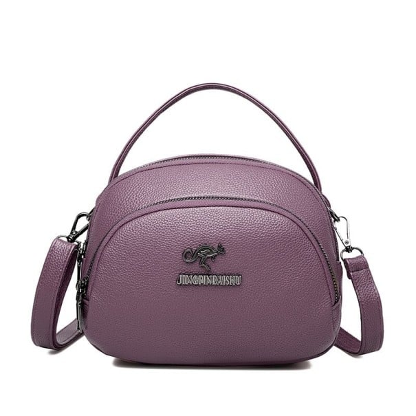 Dame crossbody taske i rund form med topgreb og rem Flere rum med lynlås Grynet PU læder 21 x 17 x 10 cm Til hånd og over skulderen lilla