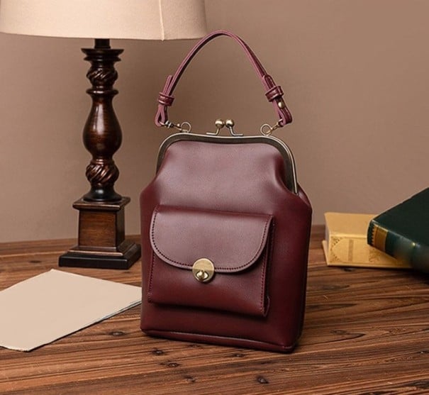 Damen Crossbody-Handtasche mit Metallrahmen und Kugelschloss Henkel und abnehmbarer Riemen Vordertasche mit Drehschloss 18 x 24 x 7 cm weinrot