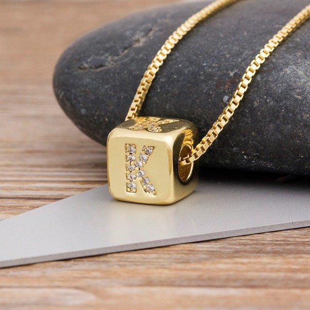 Damesketting met een letter op een kubus K
