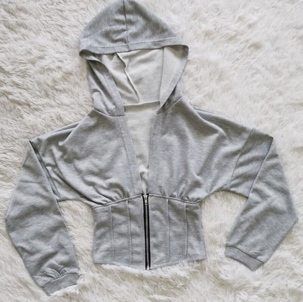 Dámská krátká mikina s kapucí v korzetovém stylu Zapínání na zip vpředu Tvarovaný pas s prošitím Dlouhé rukávy s manžetou Polyester šedá L