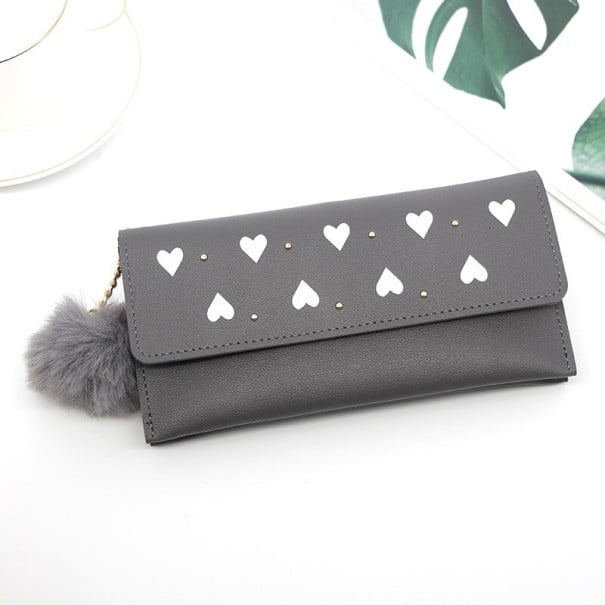 Női hosszú pénztárca klappal és fehér szívmintákkal Apró fém szegecsek Bolyhos pompon láncon Műbőr 19 x 9,5 x 1,5 cm szürke