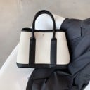 Damernas tygväska med handtag Fast form Två korta handtag Svart kantband Metallnitar på framsidan Måtten 30 x 22 x 15 cm 3