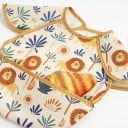 Bavetă cu mâneci scurte pentru copii 30 x 25 cm model Safari cu lei și palmieri Fundal crem și margine muștar Buzunar pentru resturi de mâncare 4