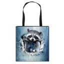Bolsa shopper para mujer con estampado realista de un animal asomando de la tela de mezclilla rasgada. Lona y poliéster. Asas negras. Forma 12