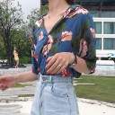 Camisa feminina solta com mangas curtas e estampado de grandes flores tropicais e folhas. Gola aberta. Fecho de botões. Algodão. 6