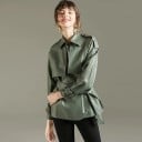Casaco feminino em pele sintética estilo trench coat Cinto para atar na cintura Ombreiras Fivelas nas mangas Gola com lapelas Corte 3