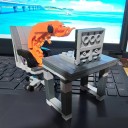 Conjunto de construção infantil em forma de camarão, que está sentado no escritório à mesa com um computador portátil numa cadeira de rodas, original 3