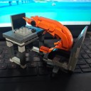 Conjunto de construção infantil em forma de camarão, que está sentado no escritório à mesa com um computador portátil numa cadeira de rodas, original 5
