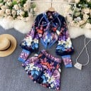 Conjunto de mujer blusa y pantalones cortos Estampado floral sobre fondo azul oscuro Blusa con lazo en el cuello Mangas abullonadas con puños altos 1