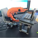 Construcción infantil linda en forma de camarón que está sentada en una oficina junto a una mesa con una computadora portátil en una silla de ruedas 2