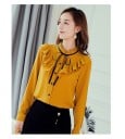 Dame chiffon skjorte med volanger fra skuldrene over brystet Ståkrave med rynket kant Sort bånd med sløjfe Lange ærmer Sorte knapper 5