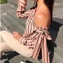Damebluse med blot skulder og stor sløjfe Asymmetrisk udskæring Skrå striber Lange ærmer med manchet Materiale polyester 4