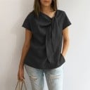 Damebluse med korte ærmer og dekorativ knude ved udskæringen Ensfarvet Løs lige pasform Uformel stil Materiale polyester 4