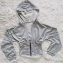 Dámska krátka mikina s kapucňou v korzetovom štýle Zapínanie na zips vpredu Tvarovaný pás s prešitím Dlhé rukávy s manžetou Polyester 2