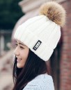 Gorro tricotado aquecido para senhora com um grande pompom peludo Forro interior de pelúcia Tricô grosso canelado Aba dobrada com emblema 16