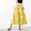 Saia longa em A para senhora com padrão floral amarelo Estrutura plástica sobre fundo branco Poliester Comprimento abaixo do joelho 3