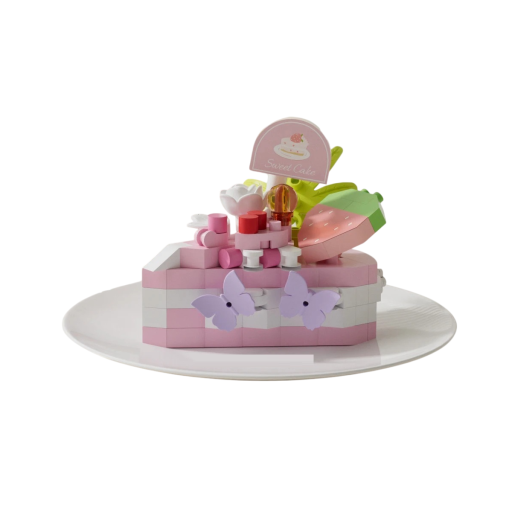 Byggsats av en rosa tårtbit med jordgubbe och fjärilar 5,5 x 3,5 x 4,5 cm Detaljdel med dekorativt sött motiv i pastellfärger och blommor