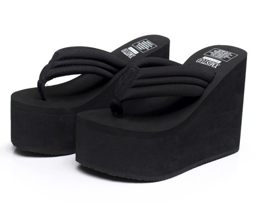 Kvinnors flipflops på en hög plattform