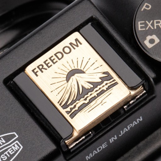 Čtvercové zlaté kovové tlačítko spouště se sluncem za horami a nápisem Soft Release pro Sony Fujifilm Nikon Leica