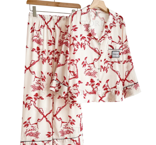 Damenpyjama in Weiß mit roten Mustern Hemd mit Kragen und langen Ärmeln mit Knöpfen und einer Brusttasche sowie Hose aus Polyester und Rayon