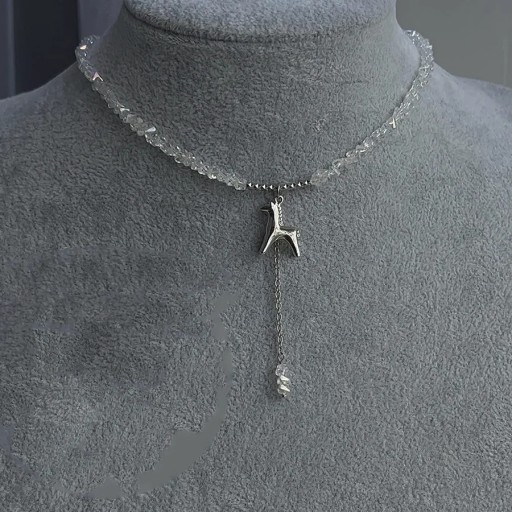 Náhrdelník z broušených korálků s přívěskem ve tvaru stylizovaného zvířete a visícím řetízkem, výrazný dekorativní šperk