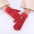 Zimowe rękawiczki damskie dotykają cegły
